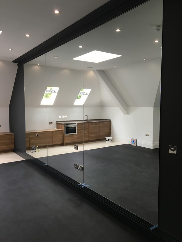 Frameless glass partition in loft conversion by Aylesbury glaziers